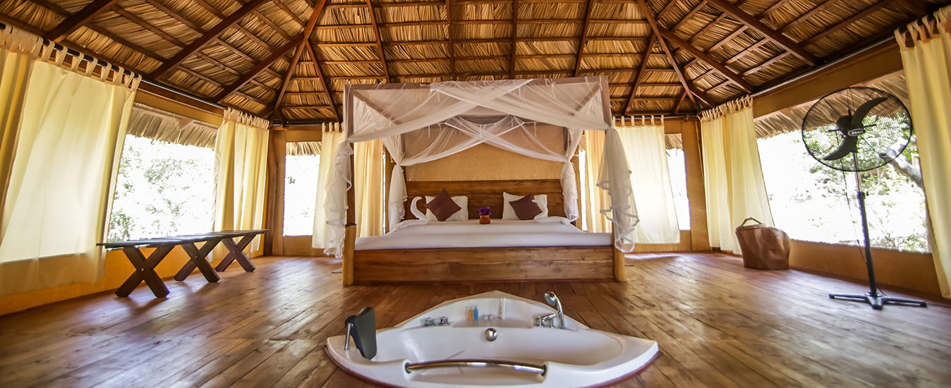 A luxury tented suite lit warmly at dusk inside Yala Tented Camp