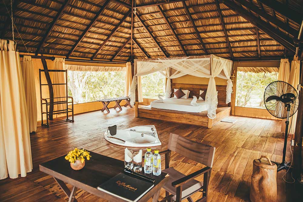 Luxury four-poster tented suite with mosquito net at Yala Tented Camp